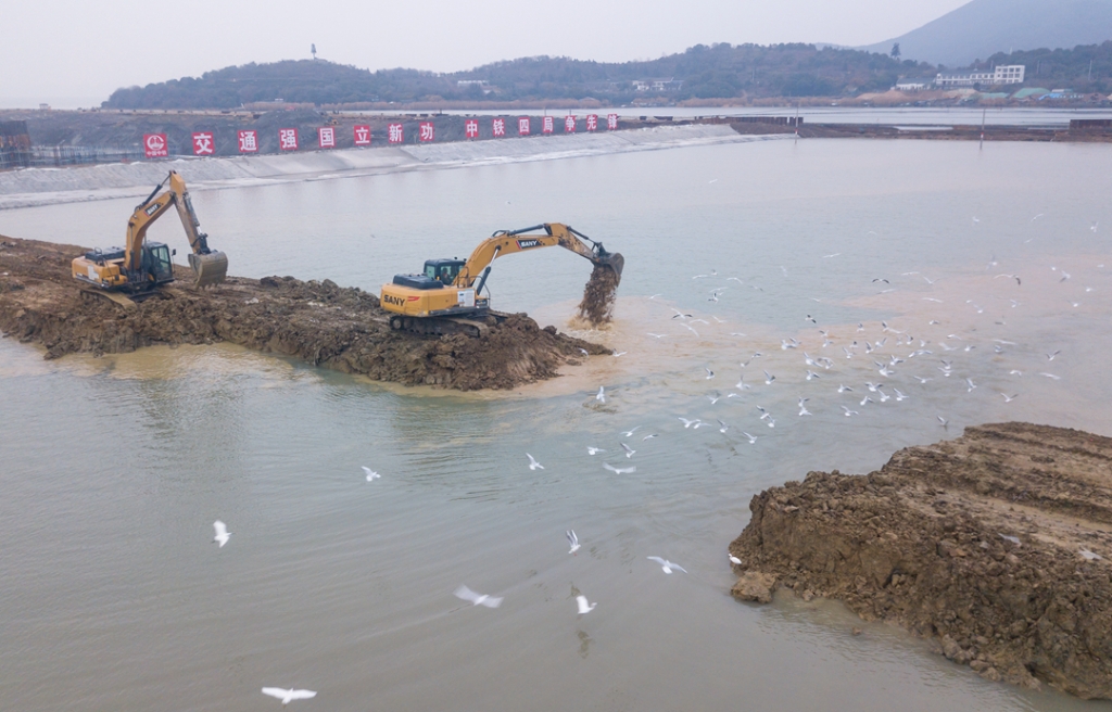 2019年12月23日，鳥群從陸島轉(zhuǎn)換圍堰回水施工現(xiàn)場飛過。